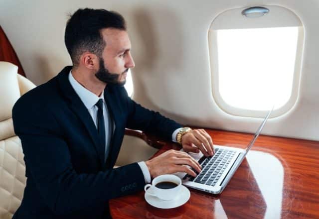 Businessman using laptop on a private jet