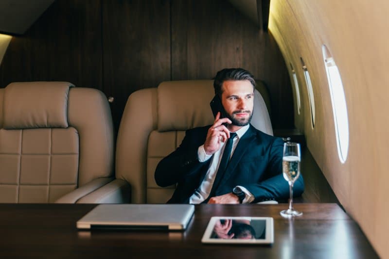 A businessman making a phone call on his private jet.