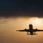 An airplane takes off at sunset