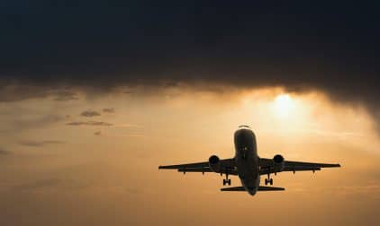 An airplane takes off at sunset