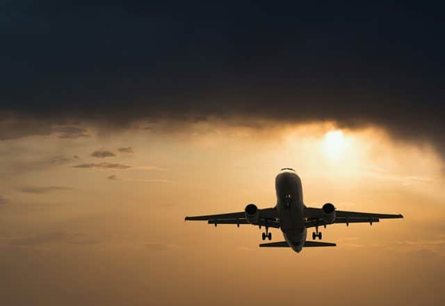 An airplane takes off at sunset