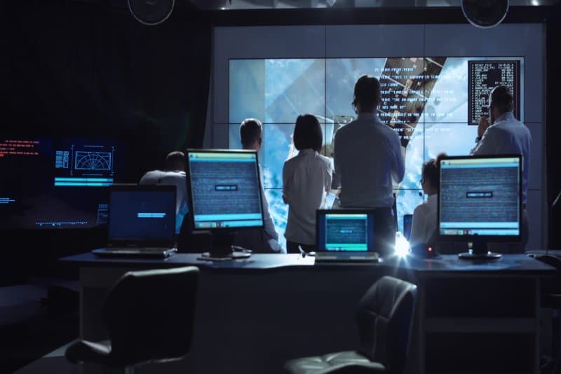 Private flight advisors monitoring a flight in a dark room.