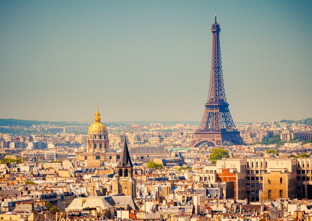 The Eiffel Tower stands tall above Paris, photographed in soft evening light.