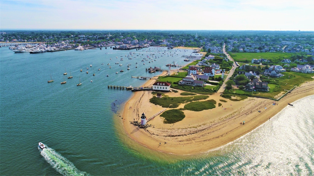 A speedboat cruises past Nantucket's iconic lighthouse and into the harbour.