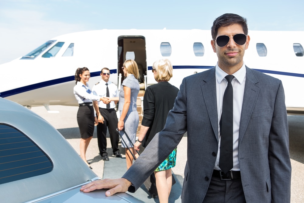 A portrait of a confident businessman in a suite getting ready to board a private jet.