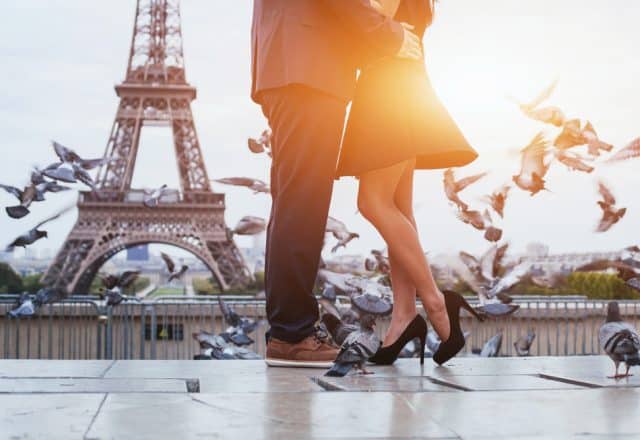 A couple celebrates their love in front of the Eiffel Tower.