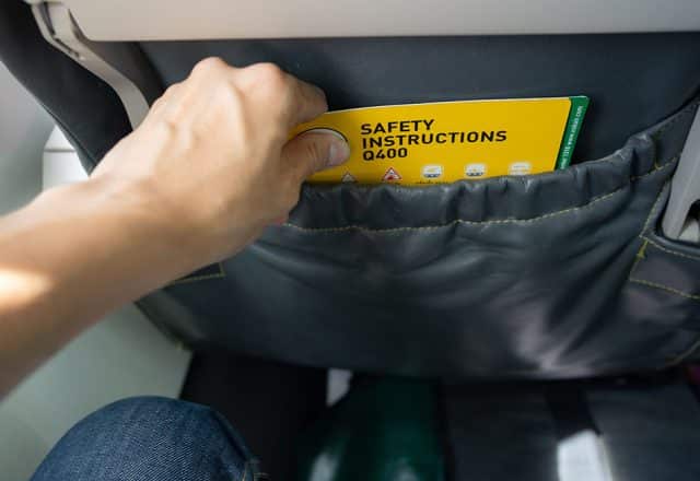 A person looking at an airline safety card