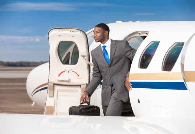 A man exits a private jet holding a briefcase